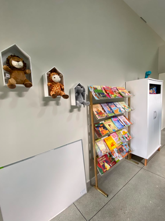Cantinho de leitura do espaço infantil com livros, brinquedos e materiais para atividades