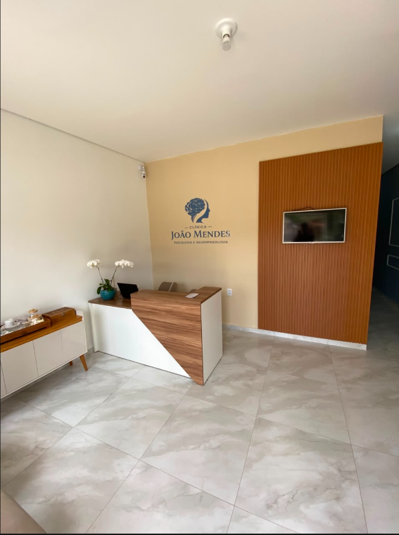 Recepção da Clínica João Mendes com balcão, identidade visual e ambiente acolhedor