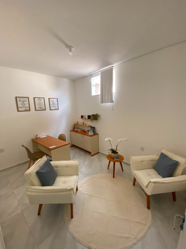 Sala de atendimento 2 com mesa, poltronas e materiais para atividades